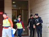 Varios agentes de Policía Nacional y la científica salen del portal donde presuntamente un menor de 17 años ha matado a su madre tras una discusión en Badajoz.
