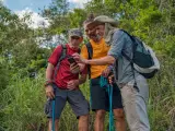 Three senior friends trying to find their way in the wilderness with the help of GPS