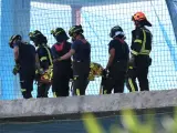 Un grupo de Bomberos mueve un cuerpo sin vida en un edificio donde se han derrumbado dos forjados este martes en Madrid.