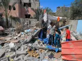 Un grupo de personas inspecciona una casa destruida en Rafah tras el ataque de Israel.