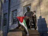 La estatua de John Harvard, primer gran benefactor del Harvard College, aparece envuelta en la bandera palestina, en un campamento de estudiantes que protestan contra la guerra en Gaza, en la Universidad de Harvard en Cambridge, Massachusetts.