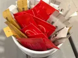 Sobres de azúcar y ketchup en un bote