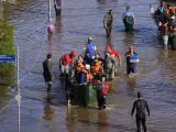 Varias personas en una zona inundada por las fuertes lluvias en Porto Alegre, Brasil.