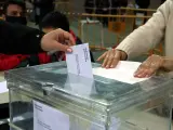 Una persona votando en un colegio electoral de Tarragona en las elecciones de 2021.