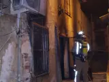 Un bombero inspecciona la casa incendiada en Ricote, Murcia.