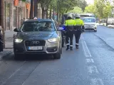 Dos agentes junto a un coche estacionado en un carril bus en Valencia.