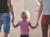 Unos padres caminan junto a su hija, en una imagen de archivo.