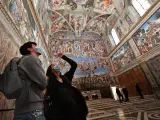 Una pareja contempla los frescos del Día del Juicio Final de la Capilla Sixtina de El Vaticano.