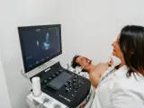 Un médico realiza una ecografía de pecho a un paciente.