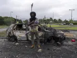Un hombre, ante un coche quemado durante los disturbios en Numea, Nueva Caledonia