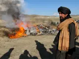 Un personal de seguridad talibán hace guardia mientras las autoridades queman drogas y bebidas alcohólicas.