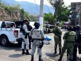 Fuerzas de seguridad custodian la escena del crimen donde agresores desconocidos dejaron los cuerpos desmembrados de Aníbal Zúñiga Cortés, candidato a concejal del municipio de Coyuca de Benítez por el centrista Partido Revolucionario Institucional, y su esposa, en Acapulco.