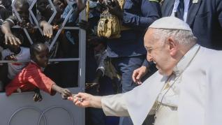 un niño entrega un billete al Papa