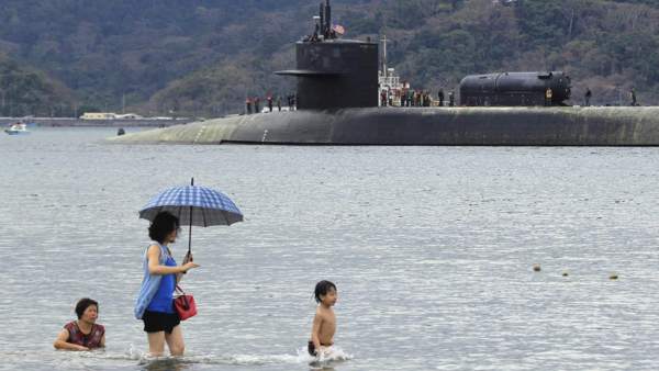 Una familia se abre paso a través del agua delante del submarino nuclear estadounidense 