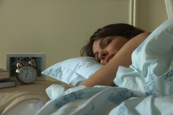 Imagen de archivo de una mujer durmiendo en su cama.