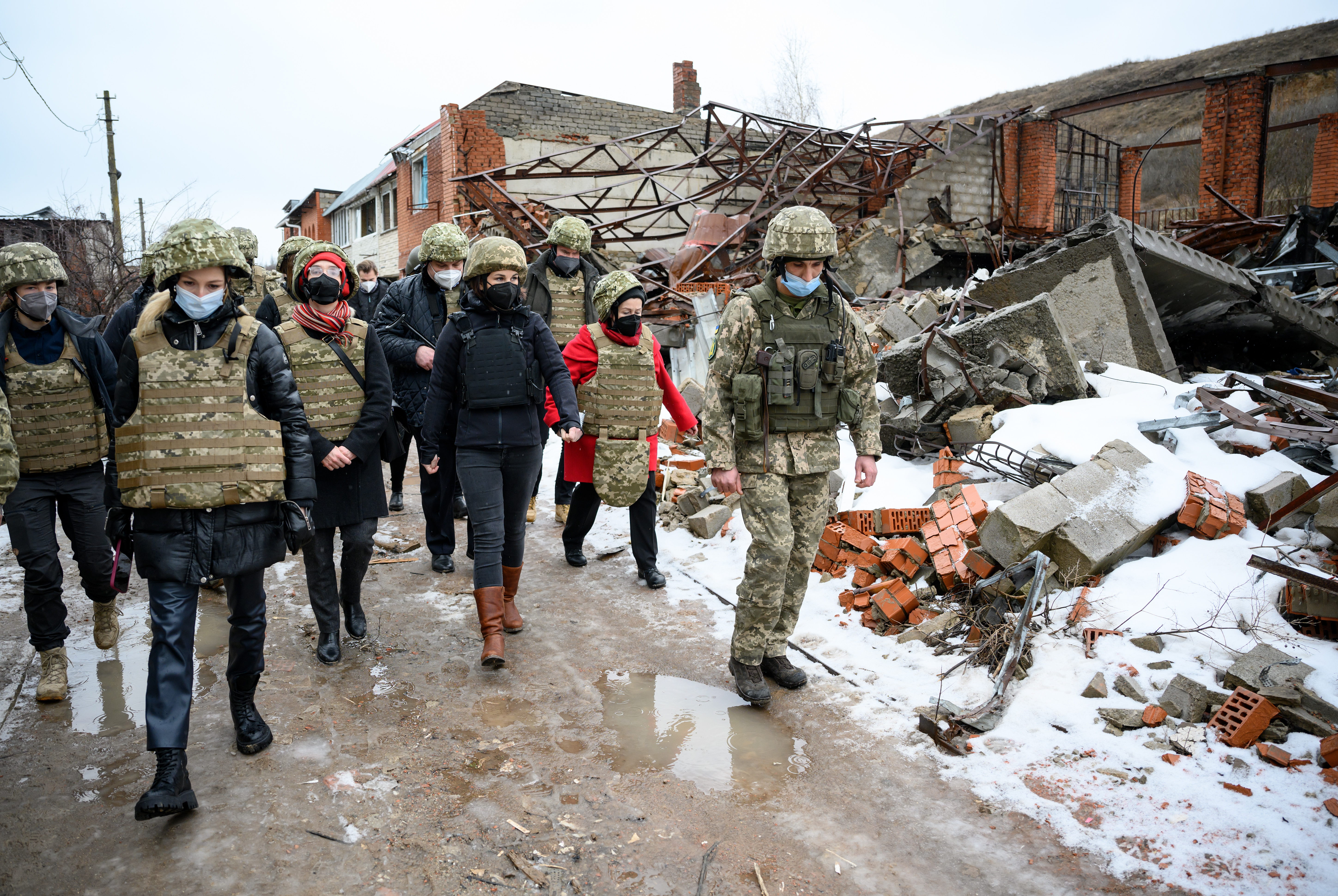 German Foreign Minister Annalena Baerbock walks along a street lined with destroyed buildings in Shyrokyne, Ukraine, on February 8, 2022.