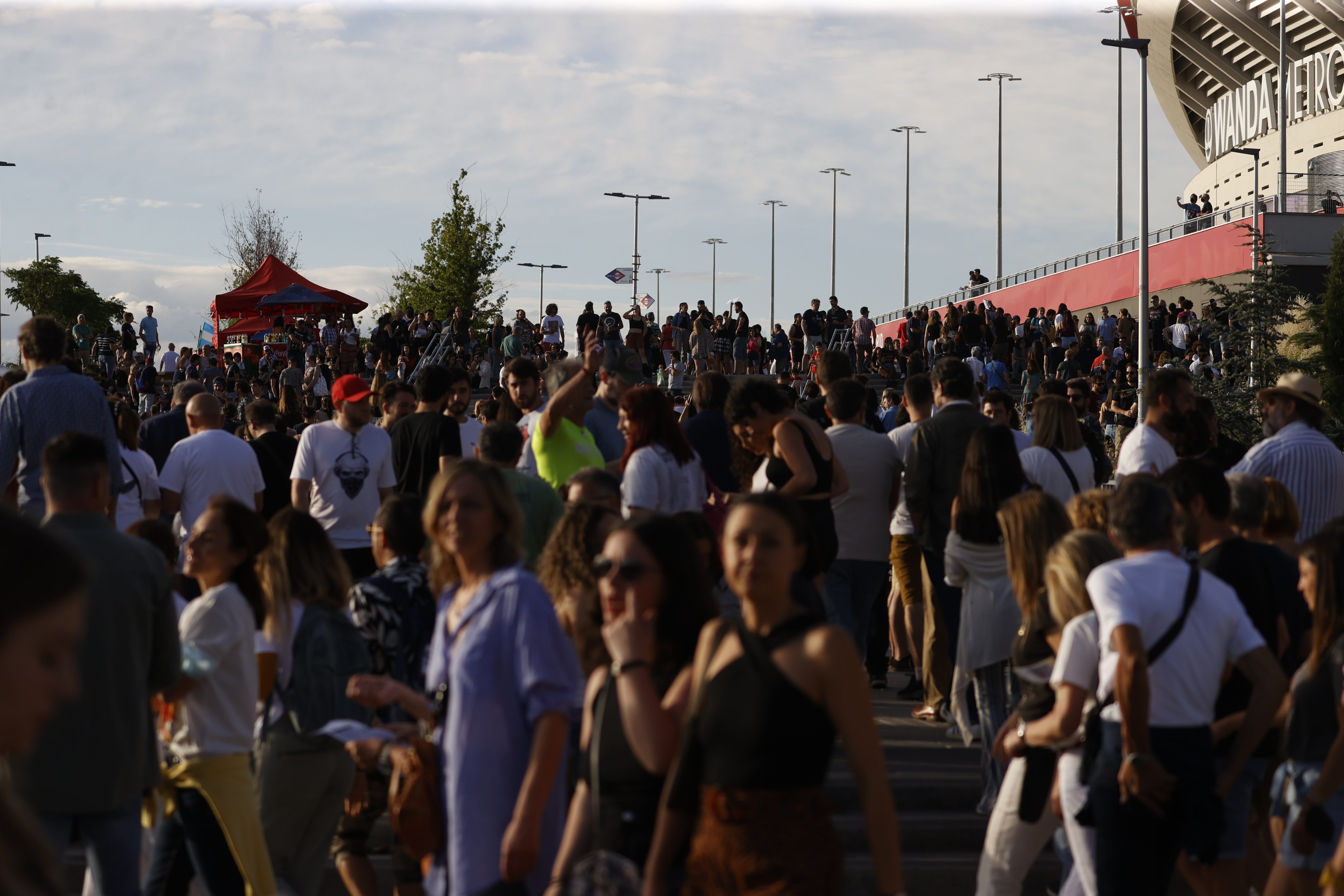 Dozens of people walk around the outskirts of the Wanda Metropolitano stadium in Madrid to attend the concert by the Rolling Stones band.