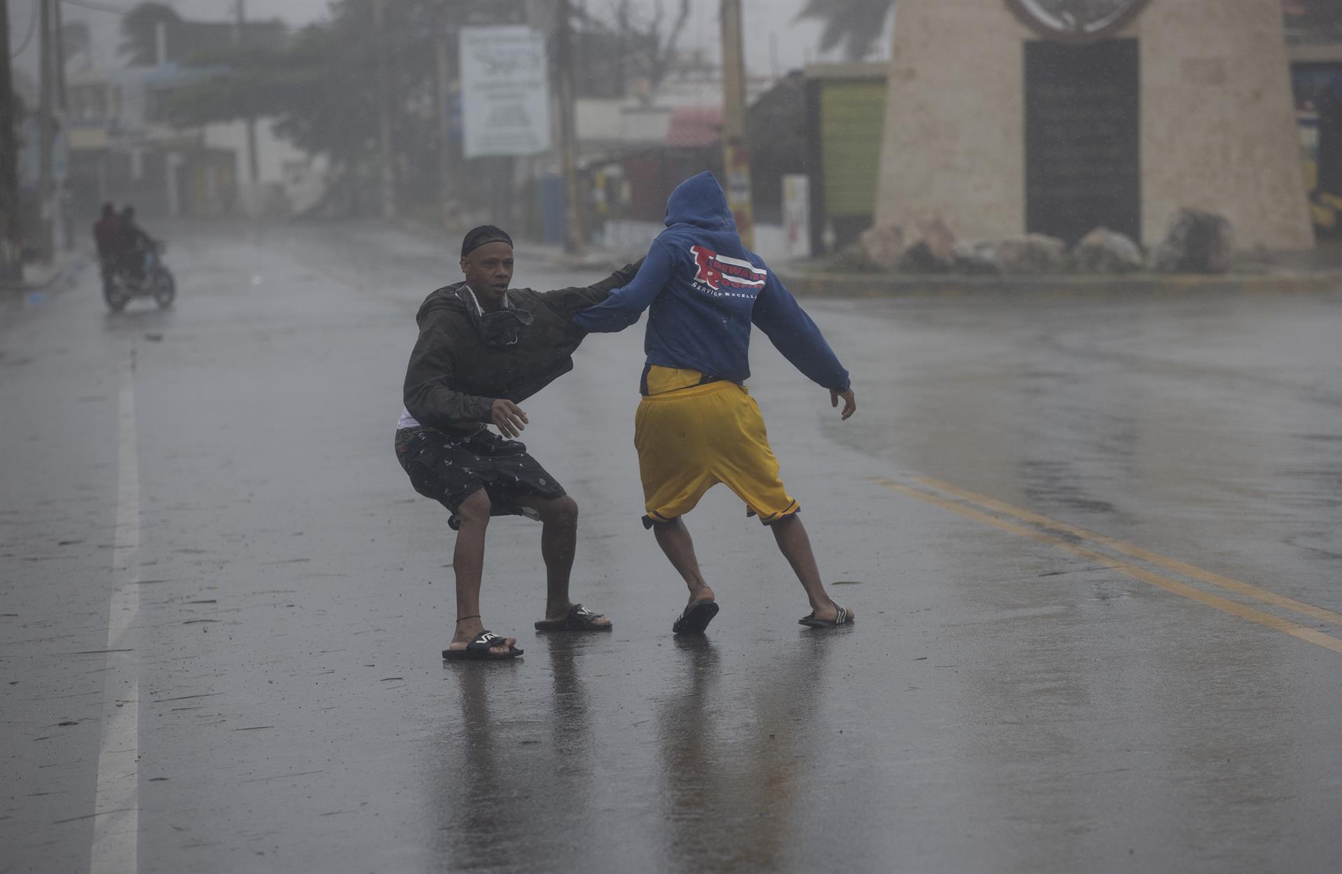Dos jóvenes caminan entre los fuertesvientos causados ​​por el huracán Fiona en Nagua (República Dominicana).