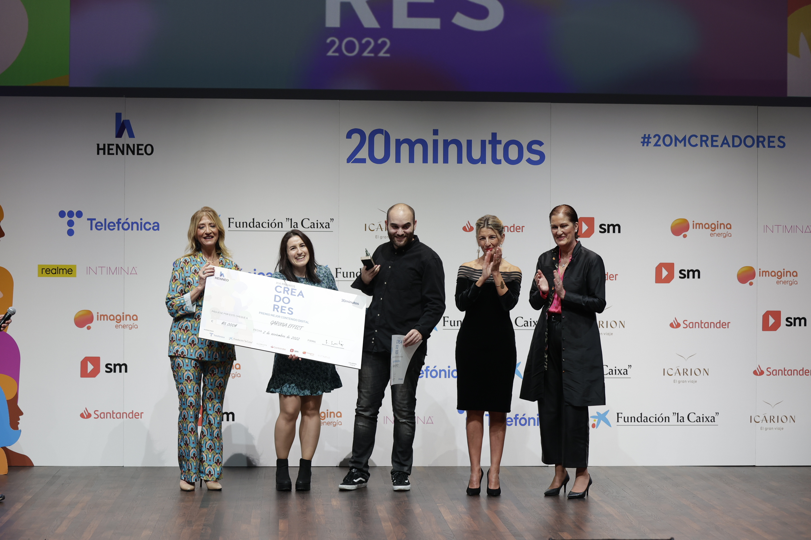 The director of '20minutos' (l), Encarna Samitier, the Minister of Labor, Yolanda Díaz, and the general director of Henneo Media (r), Laura Múgica, pose with the winners of the 2022 Creators Award (the most important in the contest), Rubén Sierra and Arima Rodríguez, for their project Garuna Effect.