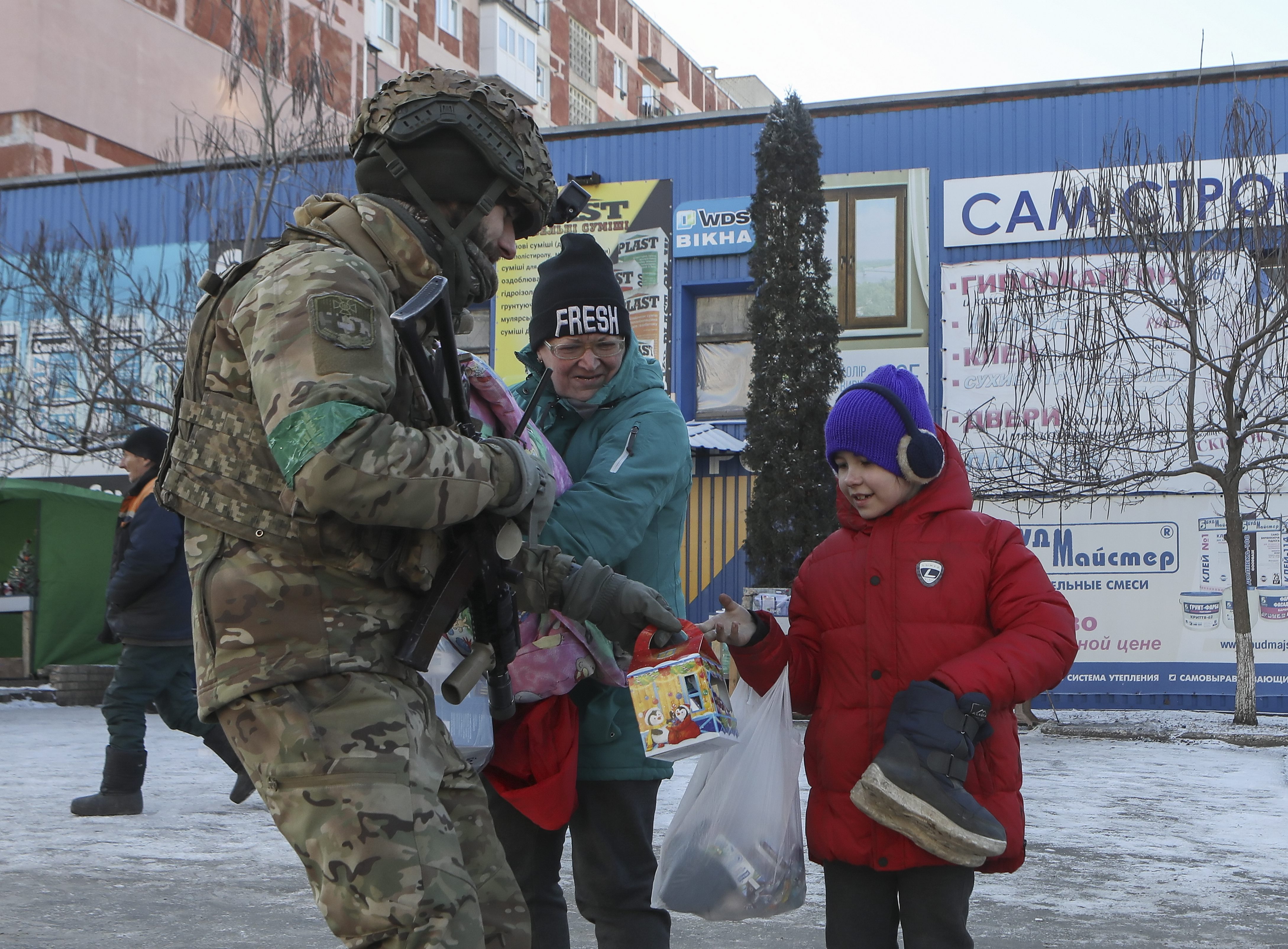 Un soldado ucraniano entrega ayuda a los habitantes de Bajmut.