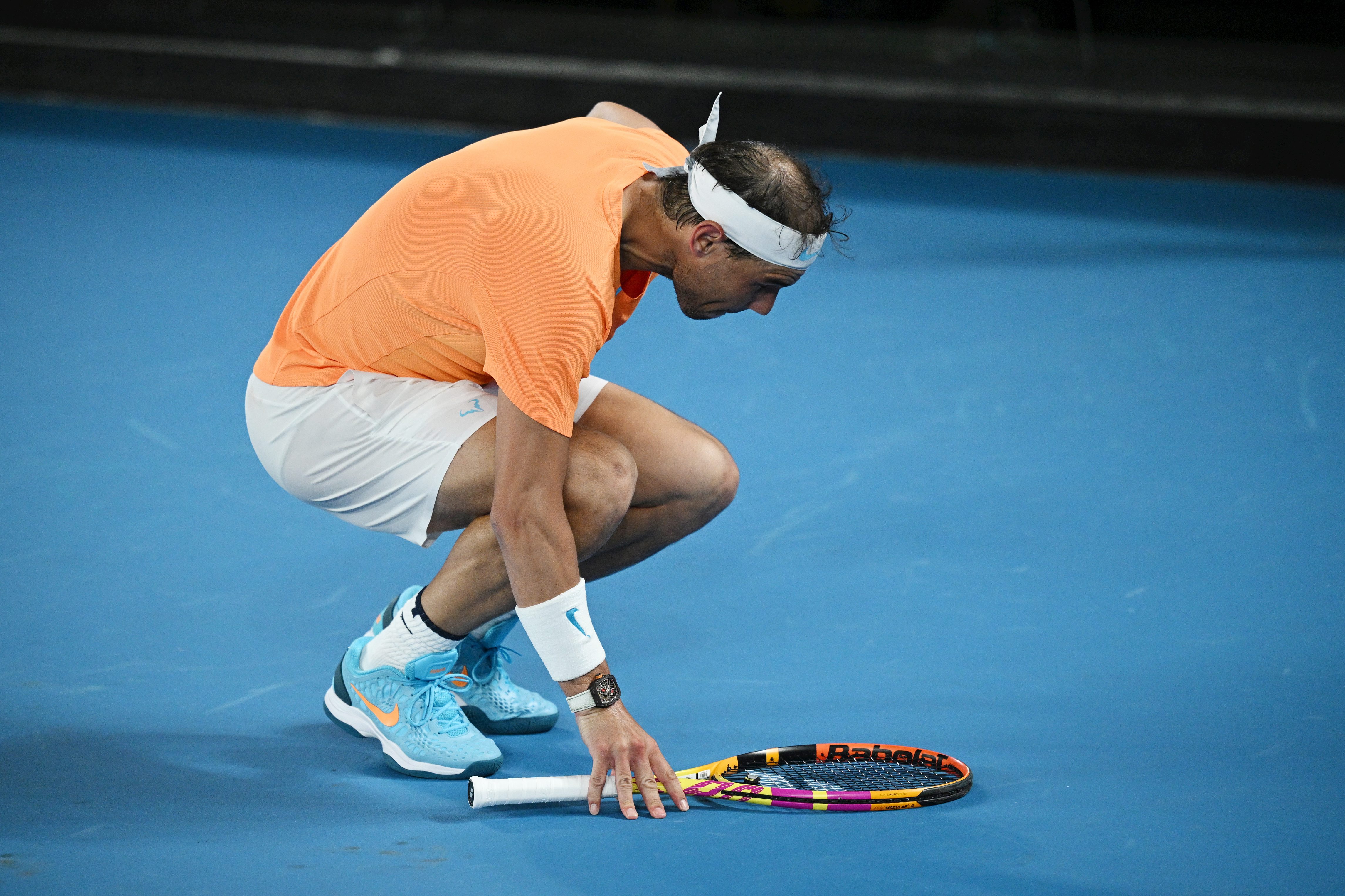 Nadal, squatting, after suffering a new episode of pain during his match against Mackenzie McDonald, in the second round of the Australian Open.