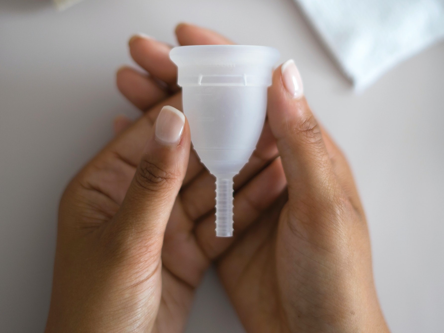 A woman holding a menstrual cup.