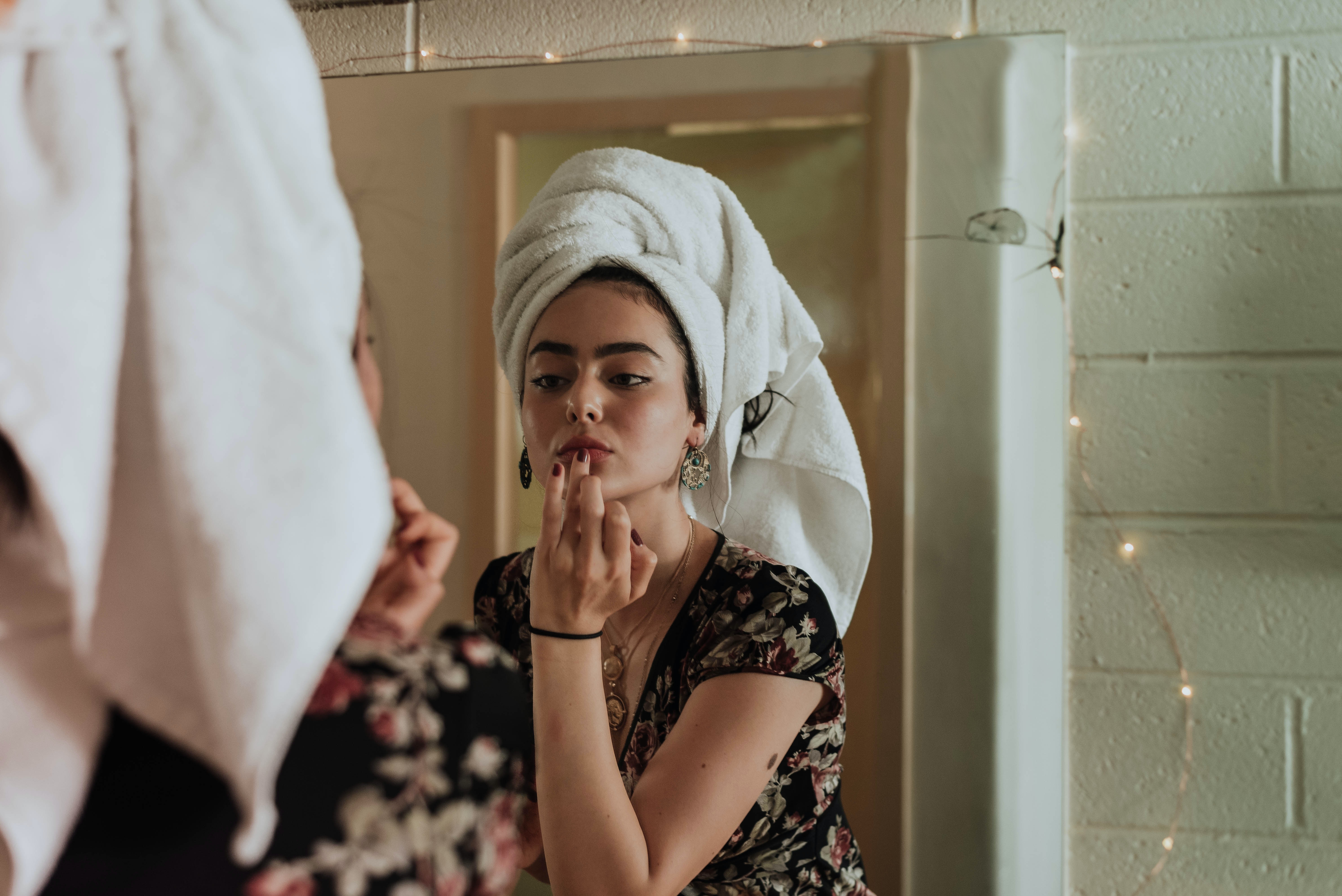 Woman putting on makeup after shower.