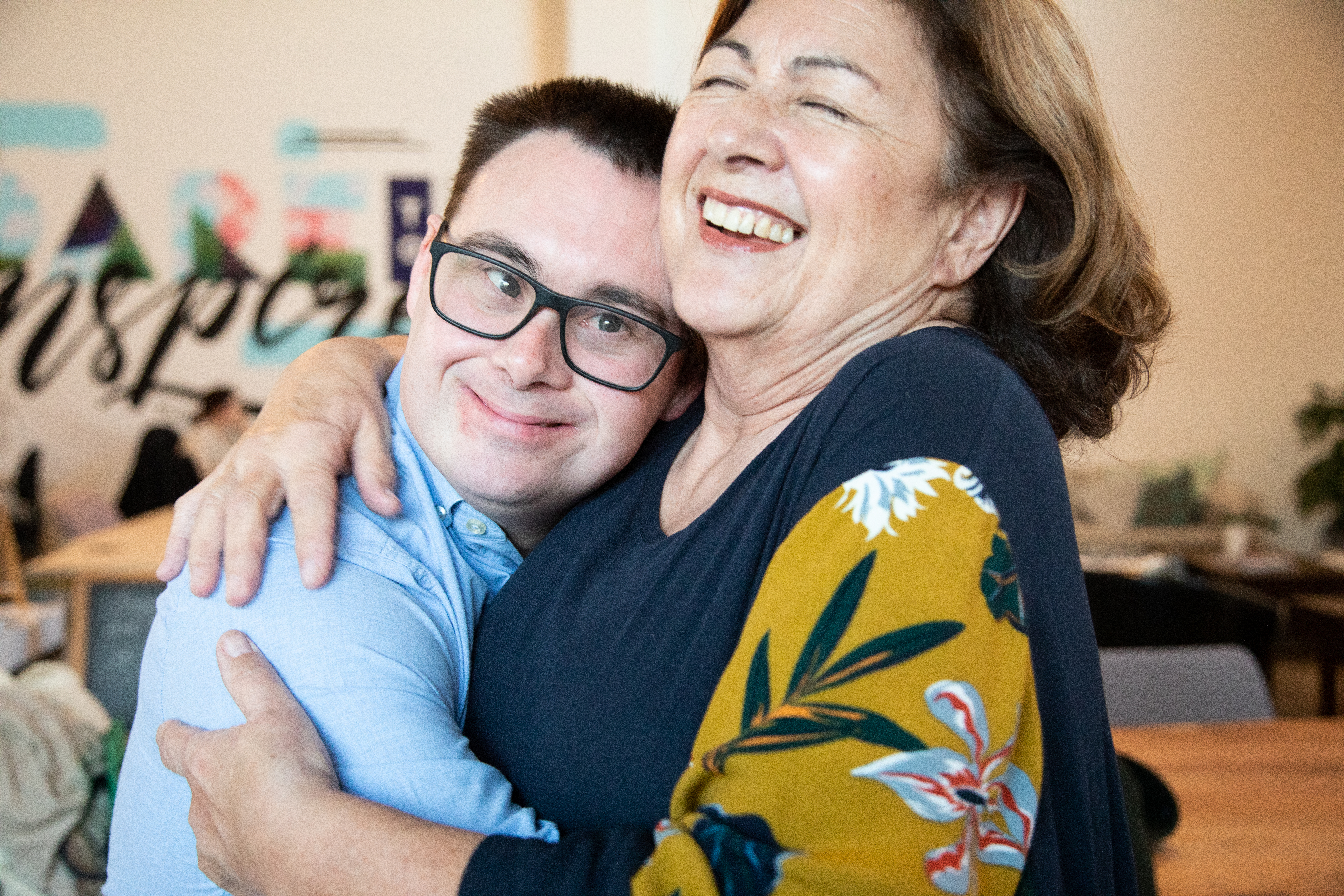 An adult man with down syndrome hugs his mother